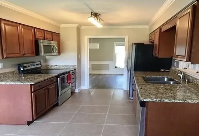 a kitchen with kitchen island granite countertop a sink stove and refrigerator