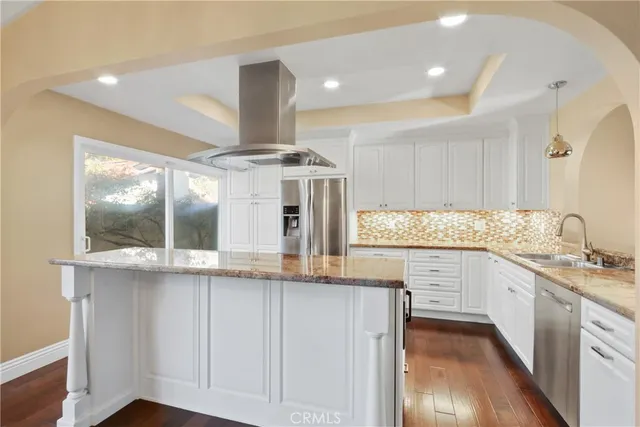 a kitchen with stainless steel appliances granite countertop a sink and cabinets with wooden floor
