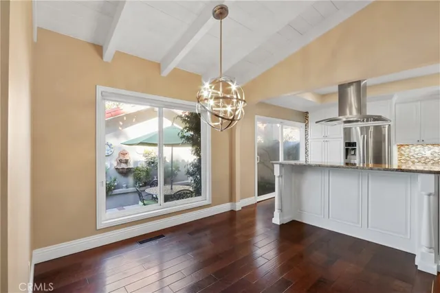 a view of a room with wooden floor a ceiling fan and windows