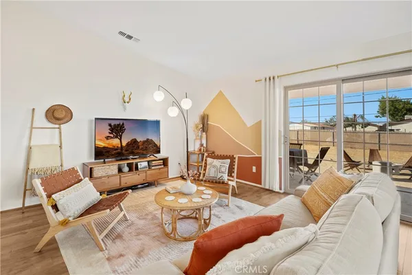 a living room with furniture a rug and a flat screen tv