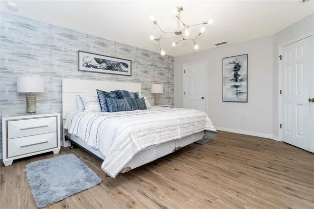 a spacious bedroom with a large bed and a chandelier