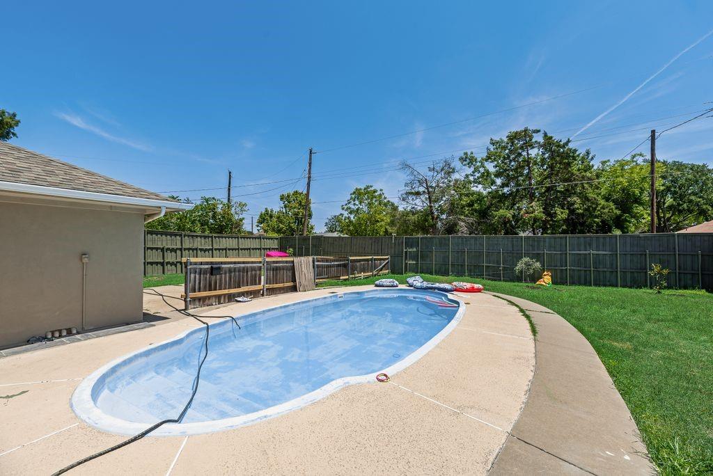 5114 Ben Davis Road Sachse, TX 75048 - Photo 14 of 28 In-ground swimming pool with a concrete surround, wood privacy fencing, and a manicured lawn area