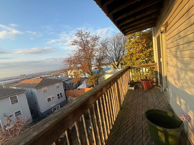 a balcony with wooden floor and furniture