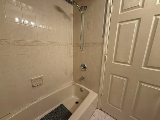 a bathroom with a tub shower and sink
