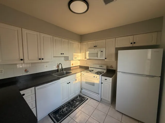 a kitchen with a refrigerator sink stove and cabinets
