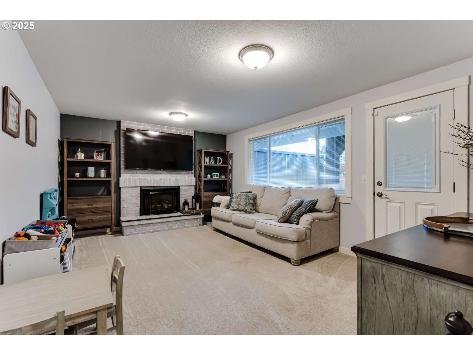 1253 Alfaretta Drive Eugene, OR 97401 - Photo 15 of 33 a living room with furniture a fireplace and a flat screen tv