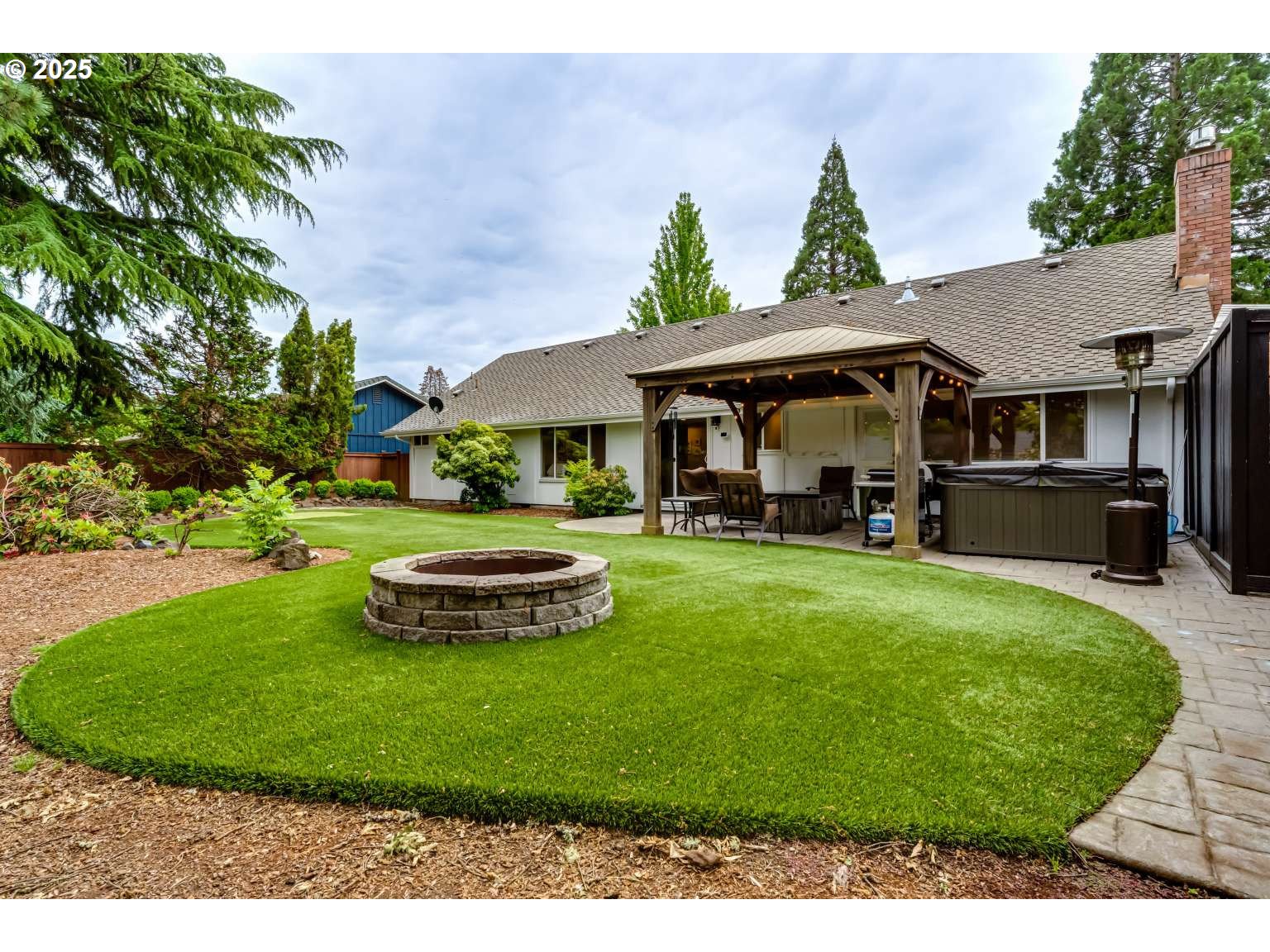 1253 Alfaretta Drive Eugene, OR 97401 - Photo 32 of 33 a view of a white house in a big yard with table and chairs potted plants and large tree