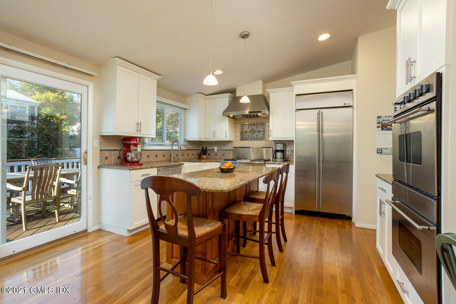 89 Florence Road Riverside, CT 06878 - Photo 11 of 34 a kitchen with stainless steel appliances a refrigerator a stove a sink dishwasher with a dining table and chairs with wooden floor
