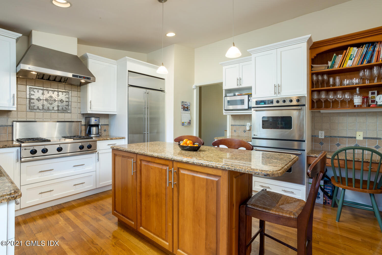 89 Florence Road Riverside, CT 06878 - Photo 13 of 34 a kitchen with stainless steel appliances a stove a refrigerator and a dining table with wooden floor