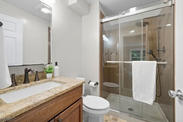 a bathroom with a granite countertop sink toilet and shower