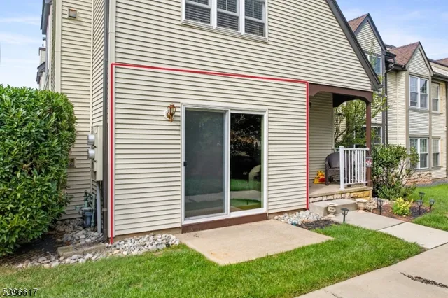 a view of a white house with a small yard and a large window