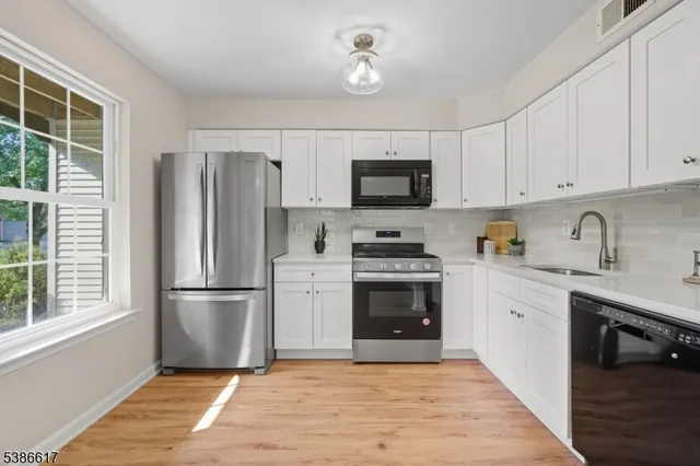 a kitchen with granite countertop a refrigerator stove and sink