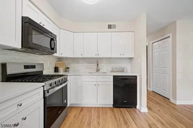a kitchen with stainless steel appliances granite countertop a stove and a wooden cabinets