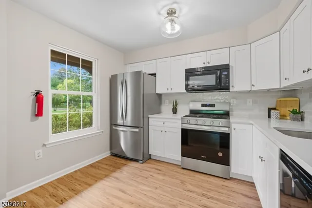 a kitchen with stainless steel appliances a stove a sink and a microwave