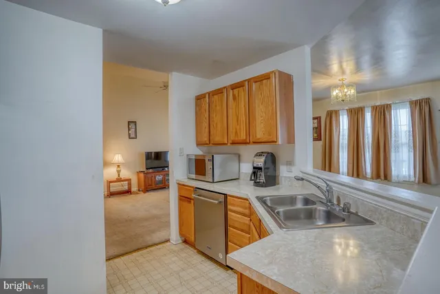 a kitchen with stainless steel appliances granite countertop a sink a stove counter space and cabinets