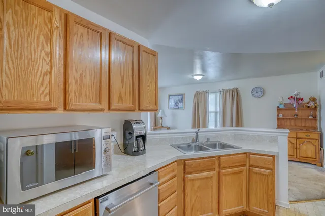 a kitchen with granite countertop stainless steel appliances a sink and cabinets
