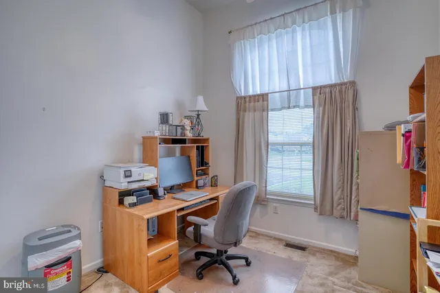 a view of a workspace with furniture and a window