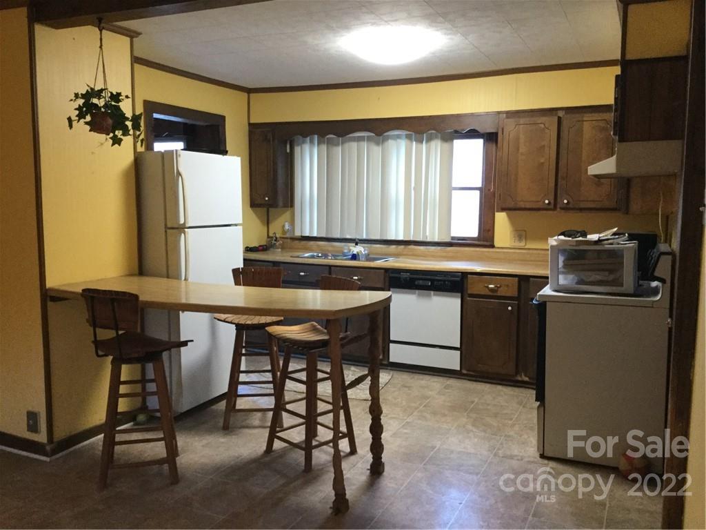 125 John Smith Road Rutherfordton, NC 28139 - Photo 7 of 13 a kitchen with a table chairs sink and cabinets
