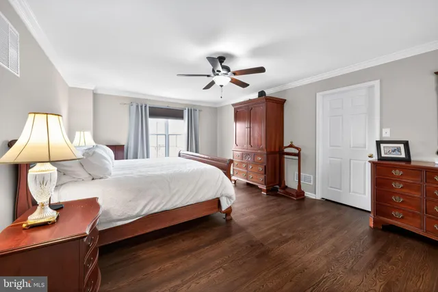 a spacious bedroom with a bed and wooden floor