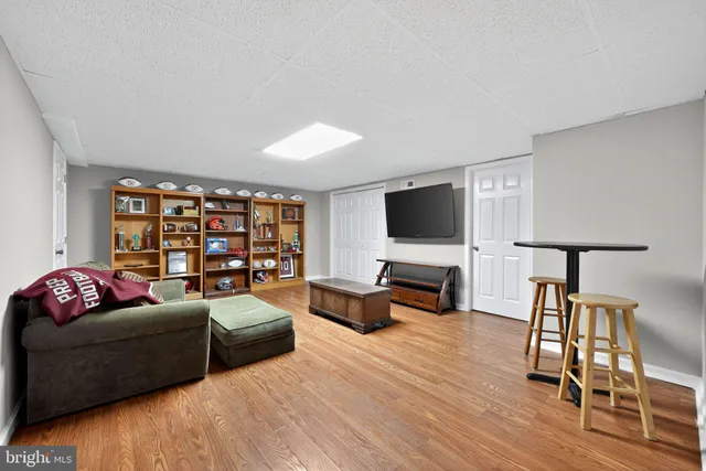 a living room with furniture flat screen tv and wooden floor