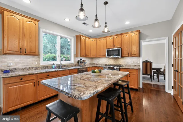 a kitchen with a stove a sink a microwave a dining table and chairs