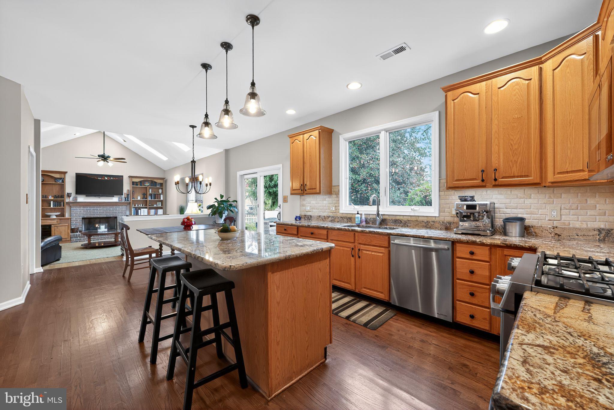 39 Bramley Road Moorestown, NJ 08057 - Photo 9 of 28 a kitchen with stainless steel appliances granite countertop wooden floor a dining table and chairs