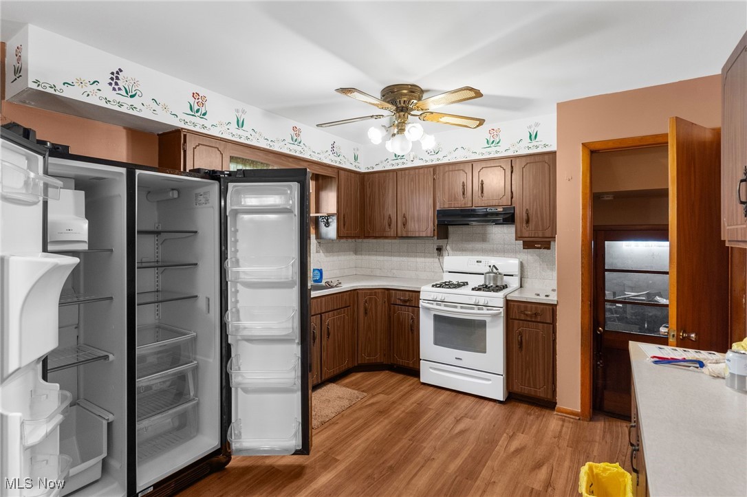 3907 Edwards Street Mineral Ridge, OH 44440 - Photo 41 of 45 Kitchen with light wood-style floors, tasteful backsplash, white gas range oven, light countertops, and freestanding refrigerator