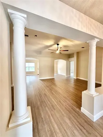 a view of a hallway with wooden floor and cabinet