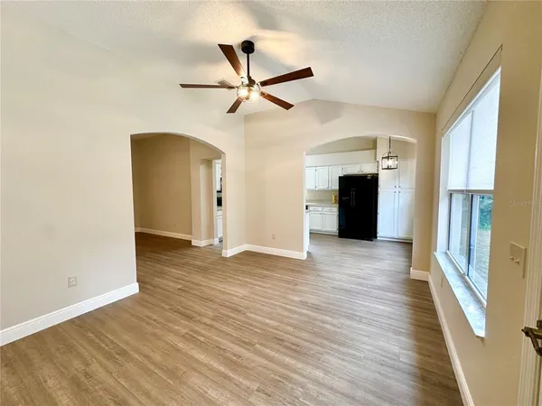 a view of empty room with wooden floor and window