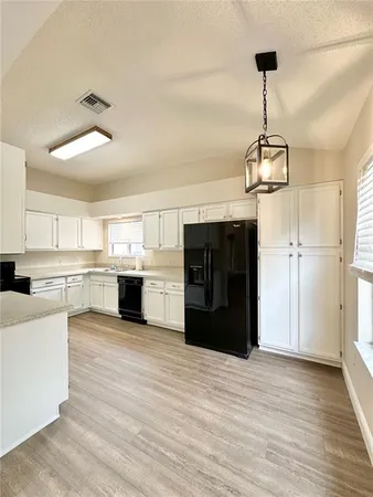 a view of a kitchen with refrigerator and cabinets