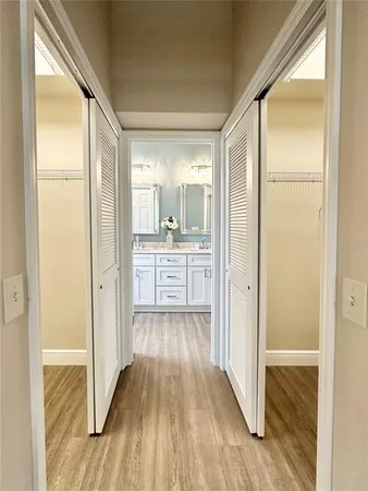 a view of a hallway with wooden floor and a kitchen