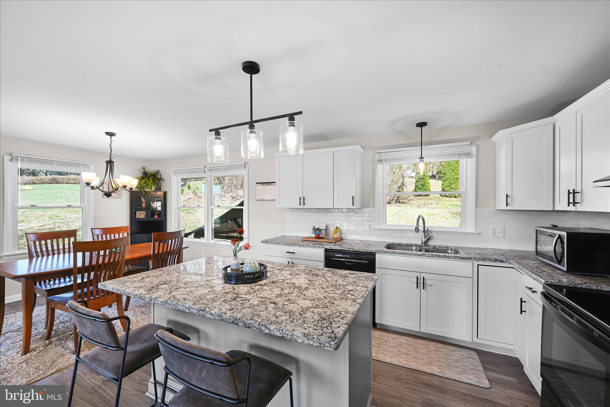 668 Scotland Road Quarryville, PA 17566 - Photo 15 of 41 a kitchen with a stove a sink a dining table and chairs with wooden floor