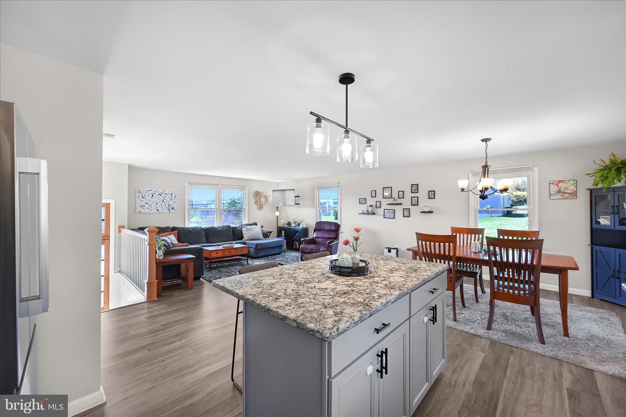 668 Scotland Road Quarryville, PA 17566 - Photo 16 of 41 a view of a dining room and livingroom with furniture wooden floor a rug a fireplace and a chandelier