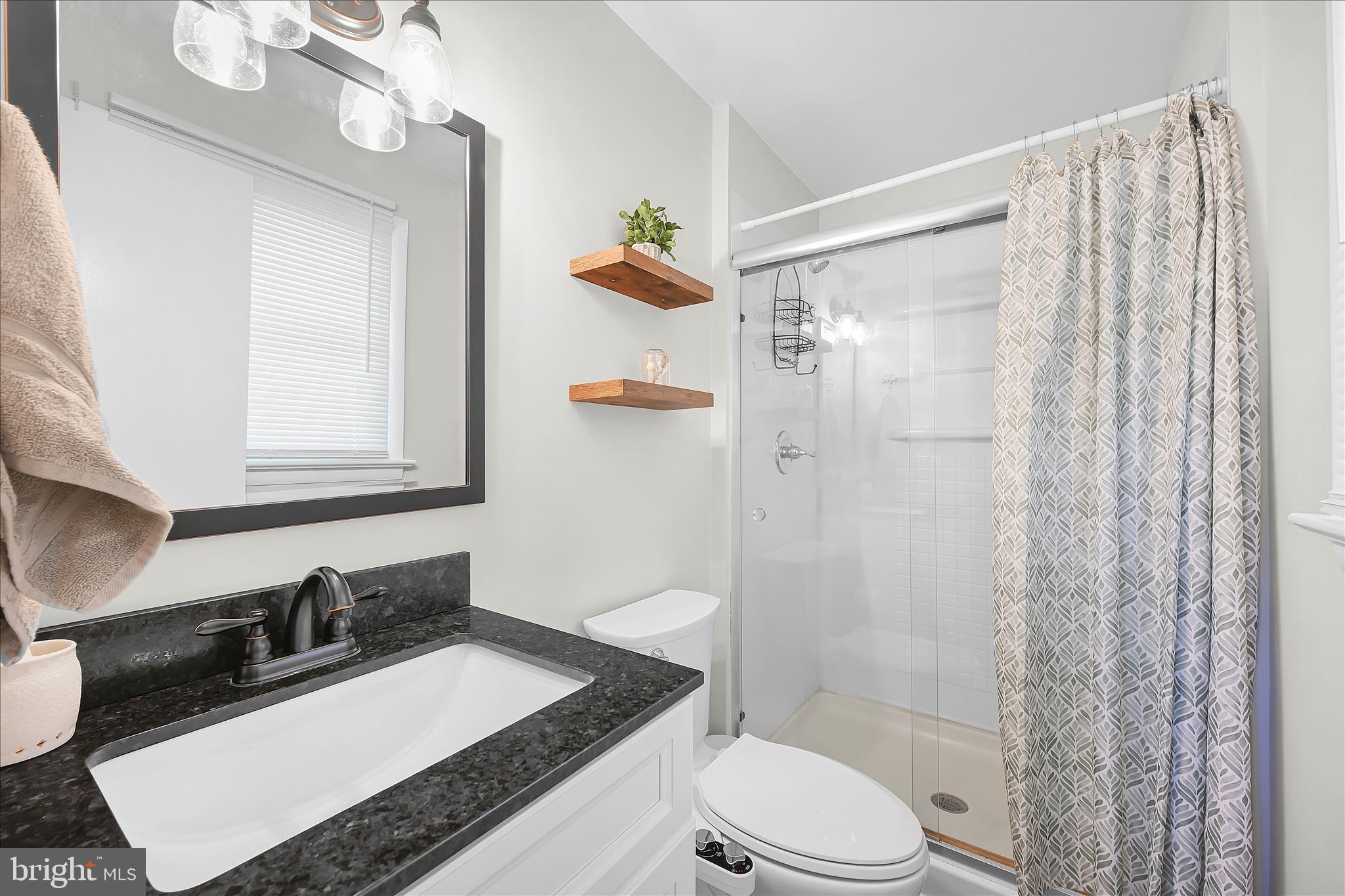 668 Scotland Road Quarryville, PA 17566 - Photo 19 of 41 a bathroom with a granite countertop sink a toilet a mirror and shower