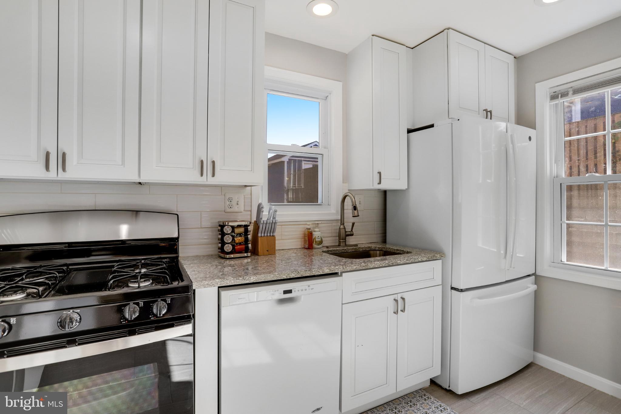 6908 Barrett Road Falls Church, VA 22042 - Photo 19 of 44 Modern kitchen with sleek white cabinetry.