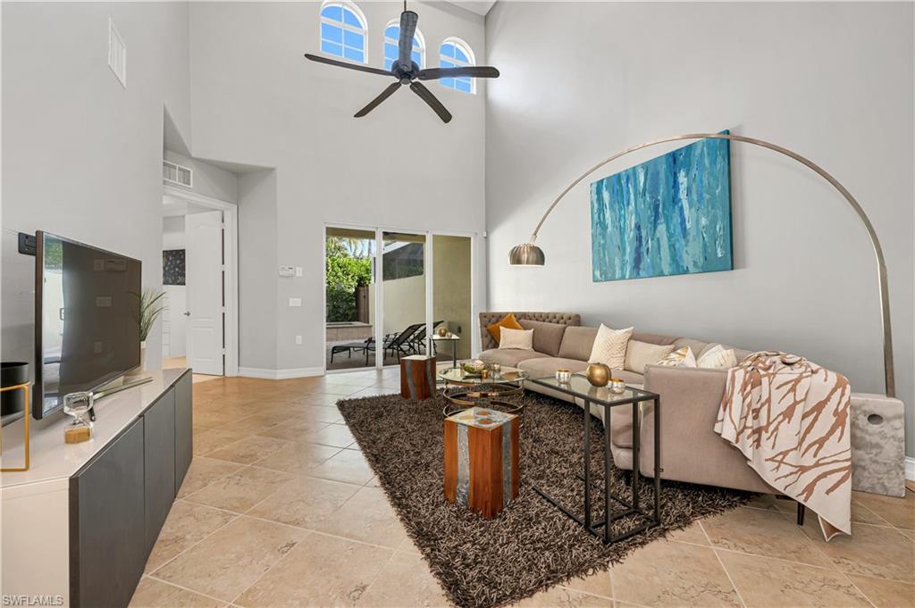 4819 West Blvd Court, Unit 103 Naples, FL 34103 - Photo 3 of 19 a living room with furniture and a flat screen tv