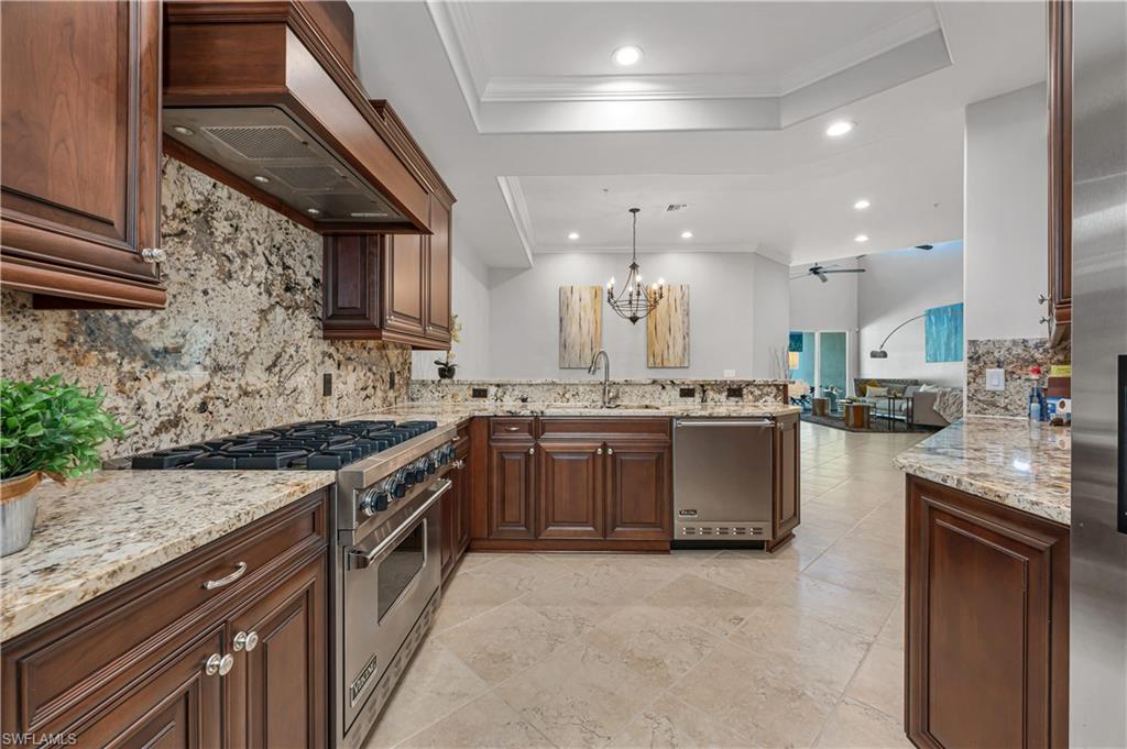4819 West Blvd Court, Unit 103 Naples, FL 34103 - Photo 4 of 19 a kitchen with stainless steel appliances granite countertop a stove a sink and a refrigerator