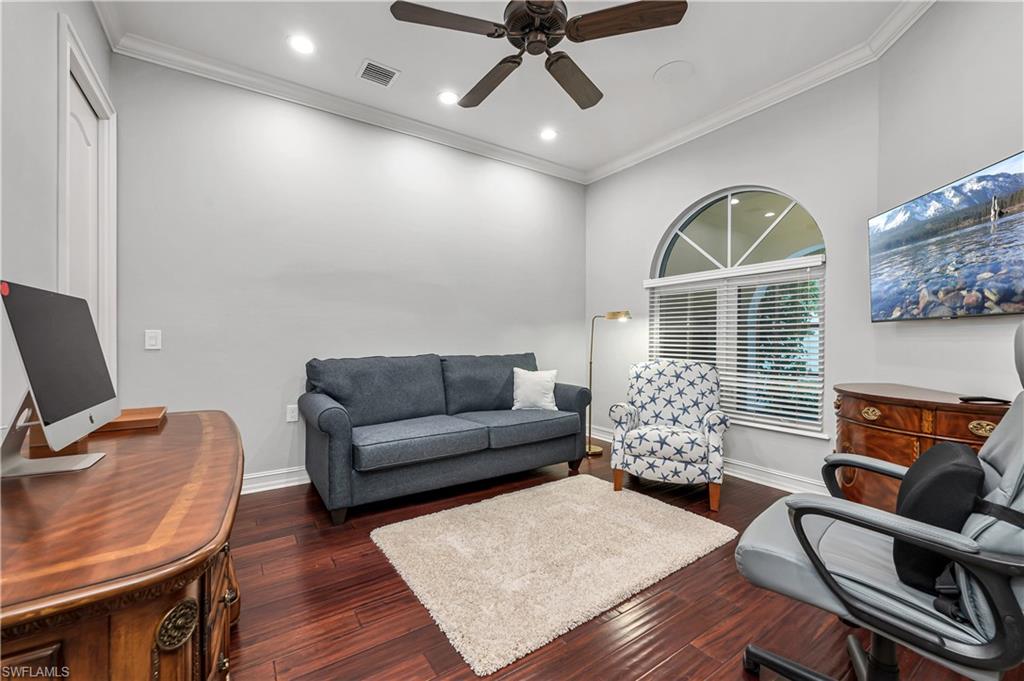 4819 West Blvd Court, Unit 103 Naples, FL 34103 - Photo 6 of 19 a living room with furniture a fireplace and a flat screen tv