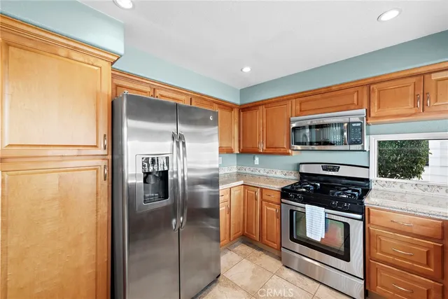 a kitchen with stainless steel appliances granite countertop a refrigerator and a stove top oven