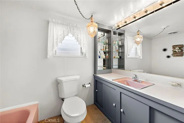 a bathroom with a sink a toilet a mirror and window