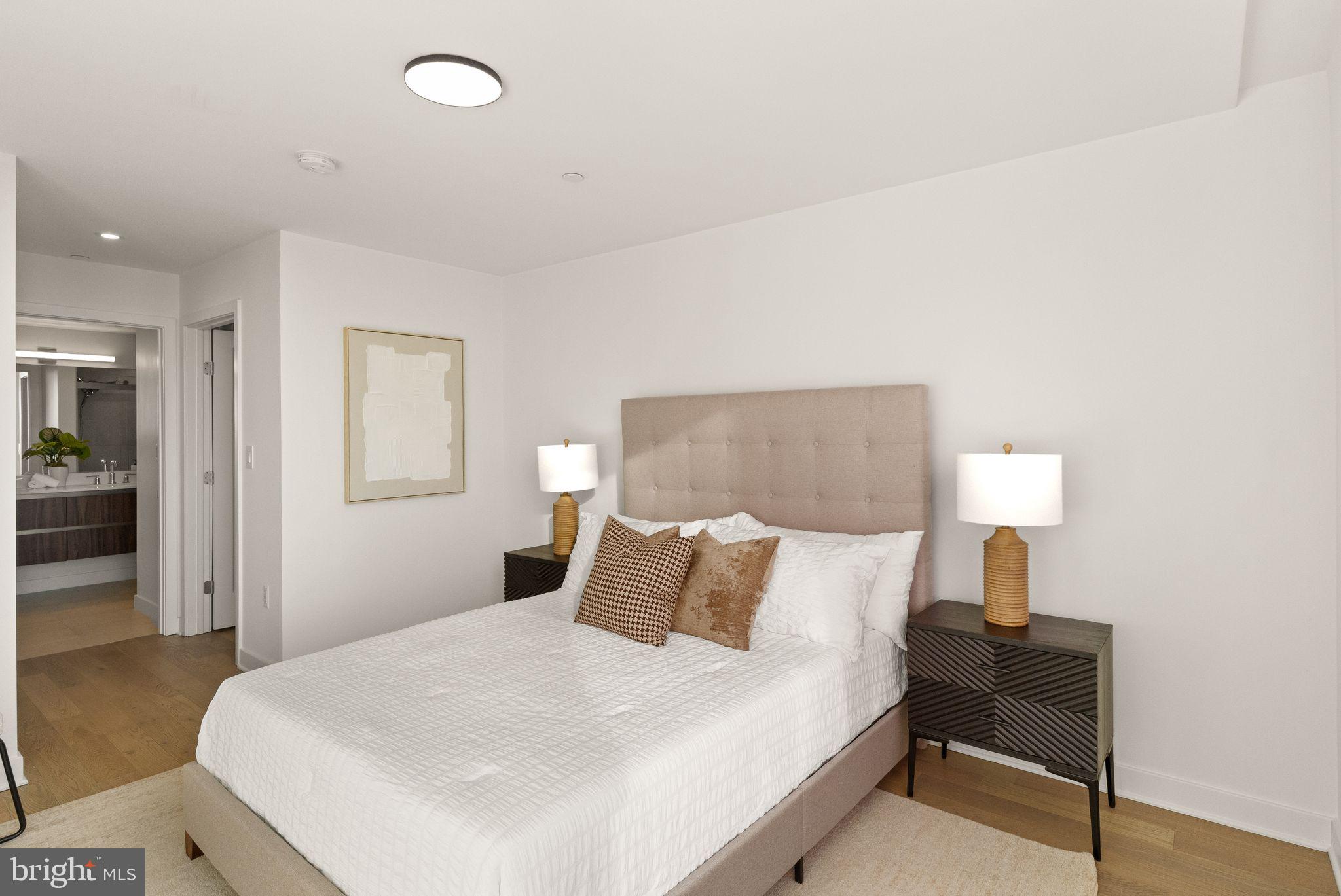 37 L Street Southeast, Unit 1102 Washington, DC 20003 - Photo 11 of 38 a bedroom with a bed and a lamp