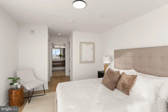 a bedroom with a bed and table chair