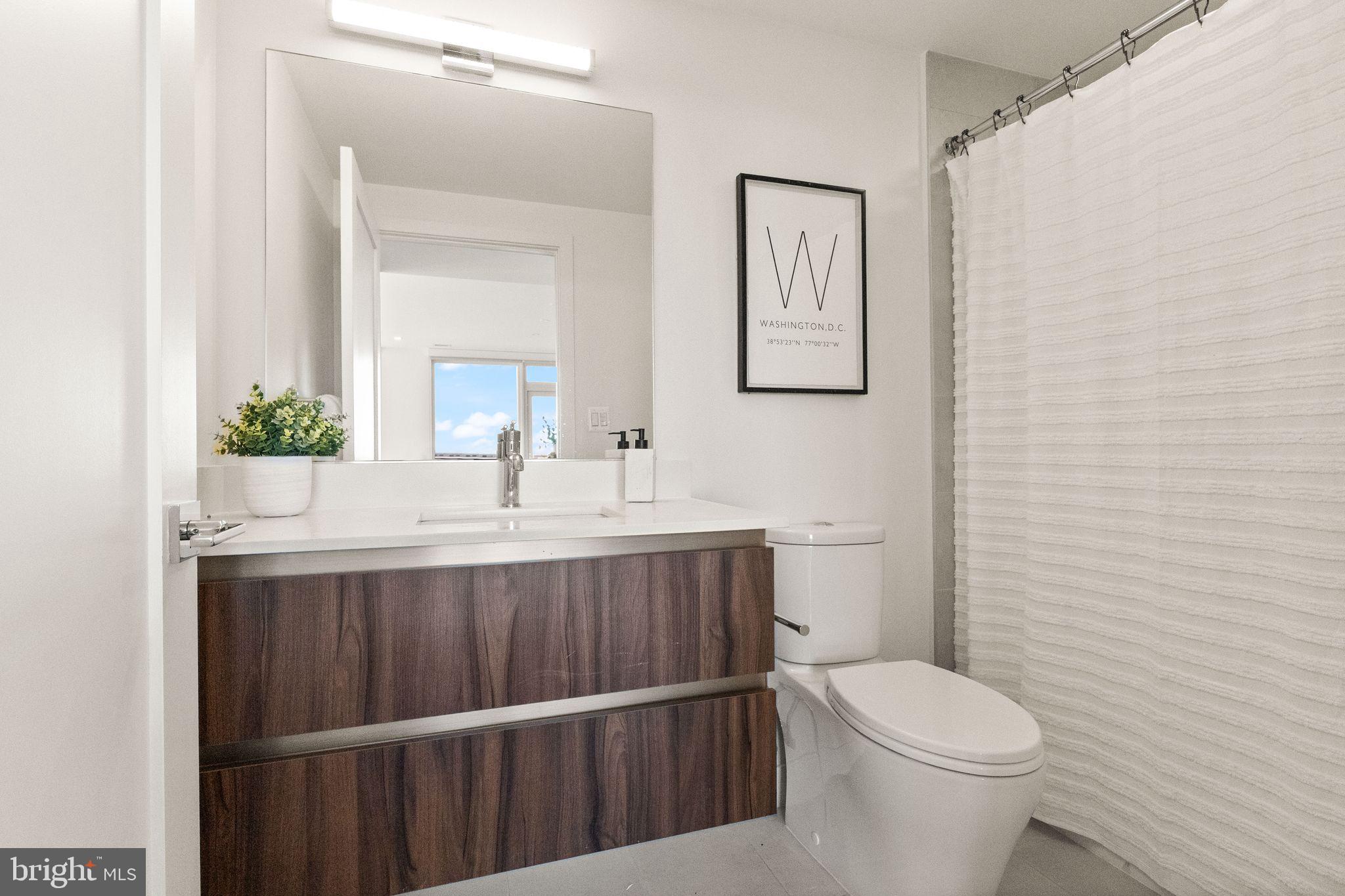 37 L Street Southeast, Unit 1102 Washington, DC 20003 - Photo 18 of 38 a bathroom with a sink a toilet and mirror