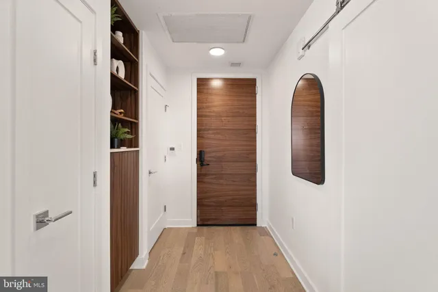 a view of a hallway with wooden floor and entryway