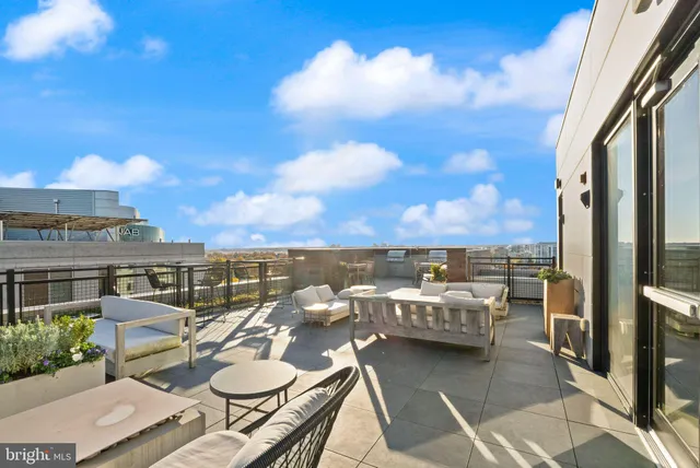 a view of a balcony with chairs and a potted plant