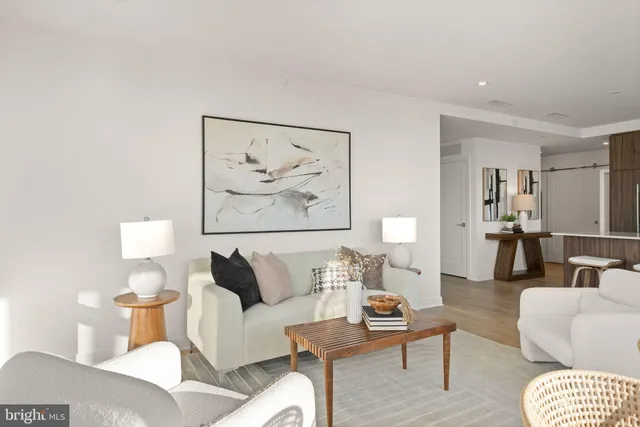 a living room with furniture and a painting on the wall