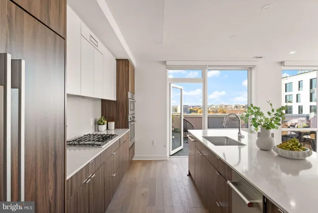 a kitchen with counter top space a sink appliances and cabinets