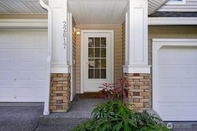 a view of front door of house with potted plants