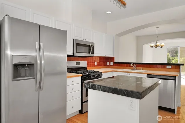 a kitchen with a center island a stove and a refrigerator