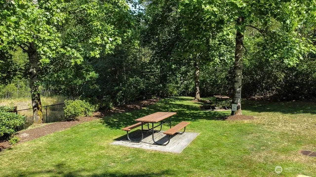 a sign that is sitting on a sidewalk in front of house